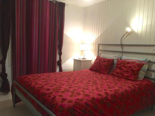 - une chambre avec un lit et une couette rouge dans l'établissement Encantadora casa en centro Piedralaves, à Piedralaves