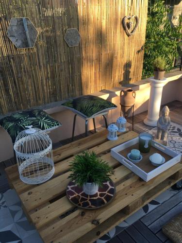 a patio with a wooden table with plants and a bird cage at La Tour Yselda in Saint-Pourçain-sur-Sioule