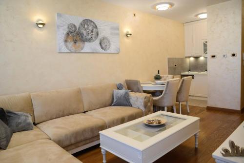 a living room with a couch and a table at Tesla 70 Apartment with secure parking In the garage in Novi Sad