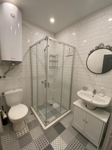 La salle de bains est pourvue d'une douche, de toilettes et d'un lavabo. dans l'établissement habitat Sea View Apartment Varna, à Varna