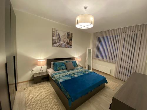 a bedroom with a bed with a blue comforter at habitat Sea View Apartment Varna in Varna City