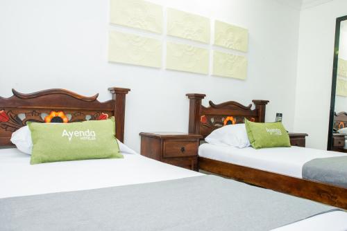 two beds sitting next to each other in a room at Ayenda 1315 Candiac in Barranquilla