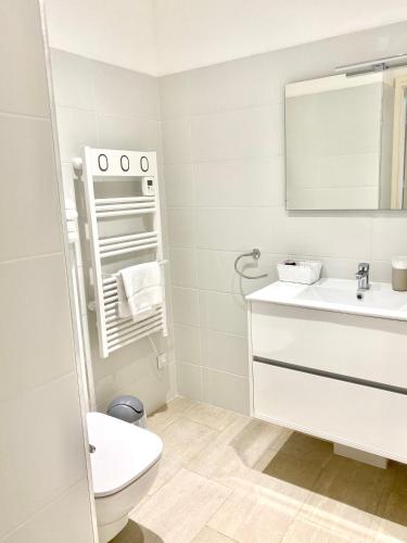 une salle de bain blanche avec des toilettes et un lavabo dans l'établissement Studio 3 personnes Front de Mer, à Tiuccia