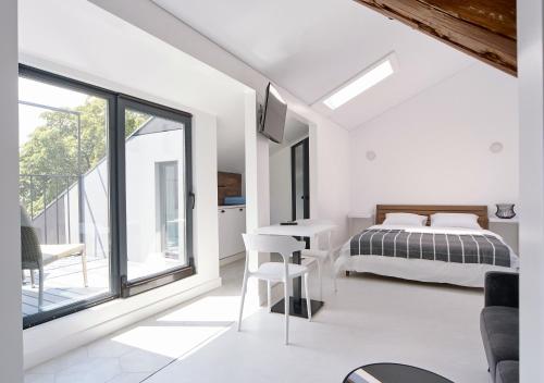 a bedroom with a bed and a table and chairs at White Door Apartments Mansard Heart of Odessa 2 in Odesa