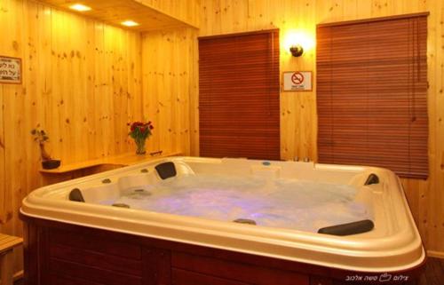 y baño de madera con bañera blanca grande. en Suites & Spa Galilee, en Kiryat Shemona