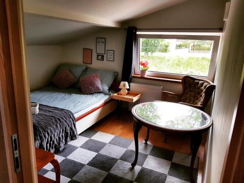 ChoczewoにあるKościuszki pokojeのベッド、テーブル、窓が備わる小さな客室です。
