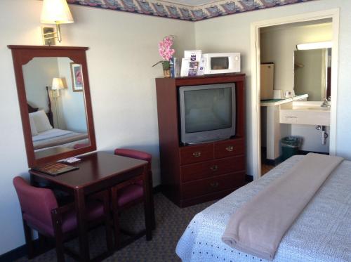 una camera d'albergo con letto, scrivania e TV di Knights Inn Peru a Peru