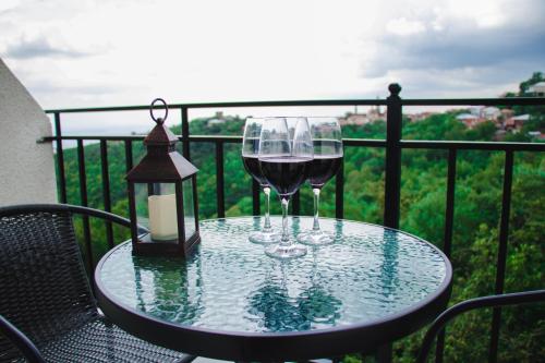 two glasses of wine on a table on a balcony at Villa Royal in Sighnaghi