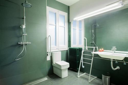 La salle de bains verte est pourvue de toilettes et d'un lavabo. dans l'établissement BacHome Gallery B&B, à Barcelone