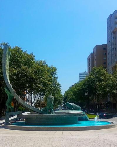 a fountain in a city with a statue of a snake at Near Beach Apartment in Póvoa de Varzim