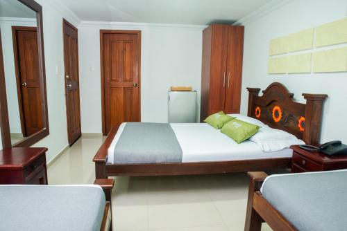 a bedroom with a large bed with a wooden headboard at Ayenda 1315 Candiac in Barranquilla