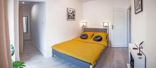 a bedroom with a yellow bed with a teddy bear on it at Corso No 7 APARTMENT in Szczawno-Zdrój