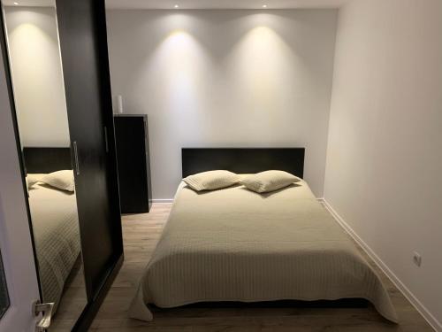 una camera con letto e specchio di Apartment City Center a Piteşti