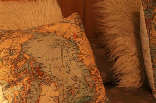 a pillow on a couch with a map on it at Posada de las Aguilas Hotel Boutique in Ezeiza