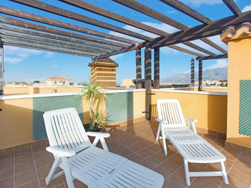 a patio with two white chairs on a roof at Belvilla by OYO Casa Los Gallardos in Los Gallardos