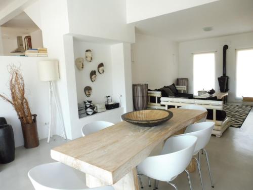 une salle à manger avec une table en bois et des chaises blanches dans l'établissement Belvilla by OYO Casa Loma, à Cala Tarida