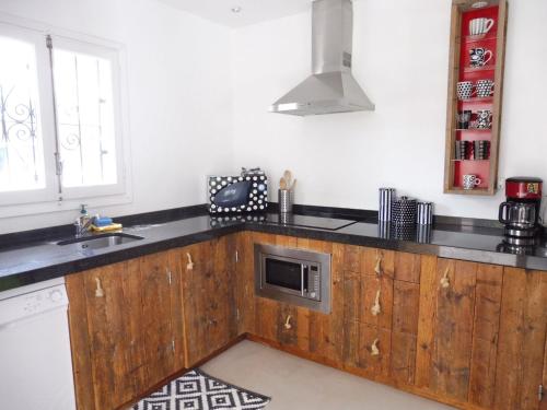 eine Küche mit einer Holztheke und einer Mikrowelle in der Unterkunft Belvilla by OYO Casa Loma in Cala Tarida