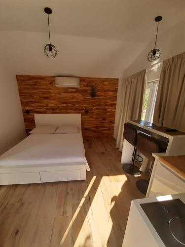 una camera con un letto bianco e un pianoforte di little olive tree house a Sali (Sale)