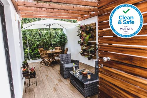 a patio with a table and an umbrella at Casa Alivas in Furnas