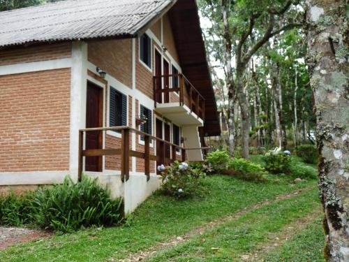 Cette maison en briques dispose d'une terrasse couverte et d'un balcon. dans l'établissement Aromas da Serra II, à Campos do Jordão
