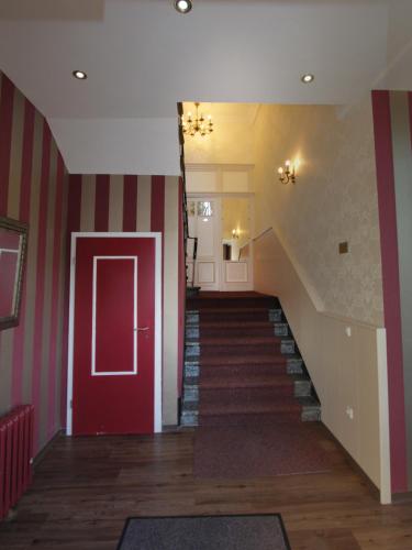 a hallway with a red door and a staircase at Gästehaus Seewarte in Flensburg