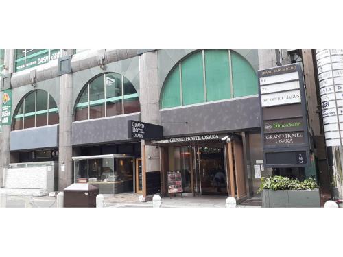 a building on a city street with a store at Shinsaibashi Grand Hotel Osaka in Osaka