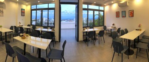 a restaurant with tables and chairs and windows at Marina Hotel Phú Yên in Tuy Hoa