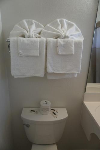 a bathroom with white towels hanging over a toilet at Valley Motel in Concord