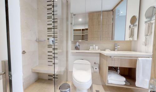 
a bathroom with a toilet, sink, and bathtub at Estelar La Torre Suites in Medellín
