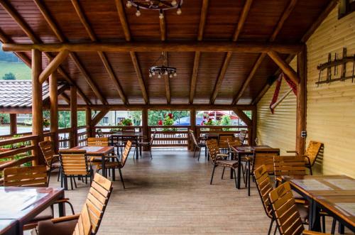 um restaurante vazio com mesas e cadeiras de madeira em LaPociu em Cimpeni