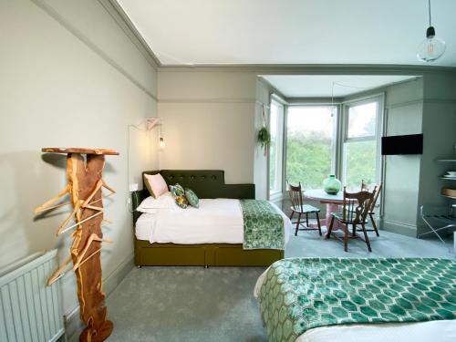 1 dormitorio con 1 cama, mesa y sillas en Sundial Stays Kendal, en Kendal