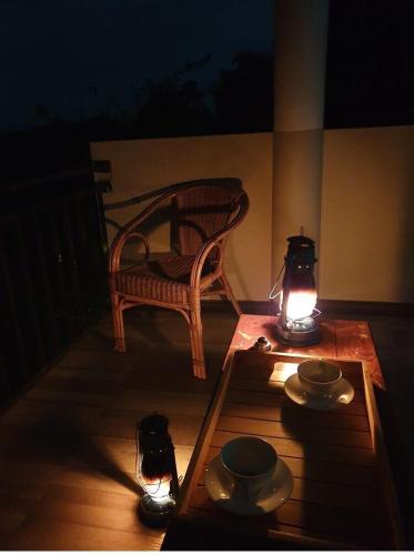 a porch with a table and a bench and lights at Desire Village Rakwana in Rakwana