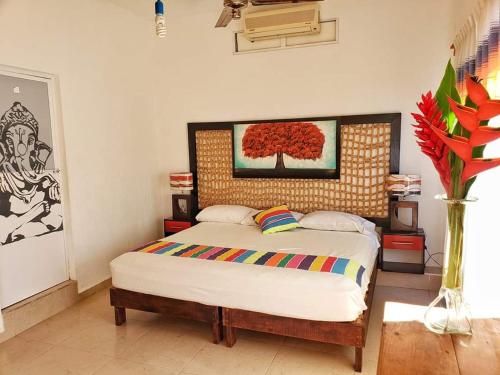 a bedroom with a bed and a painting on the wall at Casa de Huespedes Cielito Lindo in Santa Cruz Huatulco