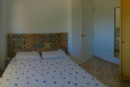 een slaapkamer met een bed met blauwe en witte lakens bij Apartamento primera línea in Denia