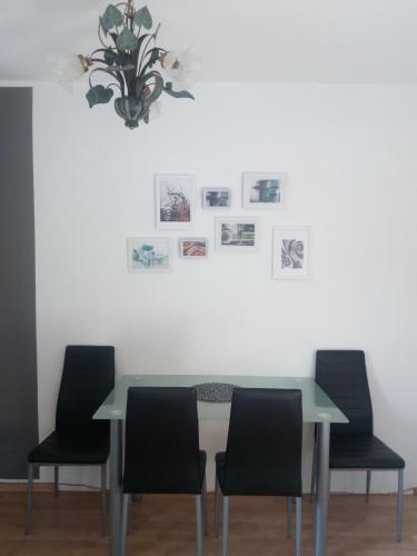 a dining room table with chairs and pictures on the wall at Landhaus Tirol in Presseggersee