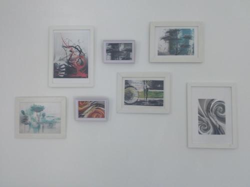 a group of framed pictures on a white wall at Landhaus Tirol in Presseggersee