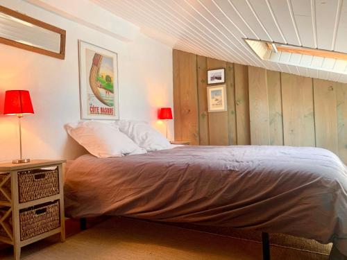 a bedroom with a bed and a table with lamps at Balea Gorri in Ciboure