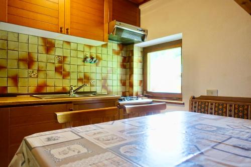 a kitchen with a table and a sink at Ciasa PREROMAN Mansarde in San Martino in Badia