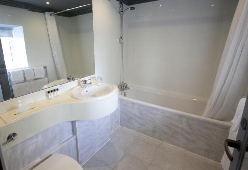 a bathroom with a sink and a bath tub at St James Hotel; BW Premier Collection in Nottingham