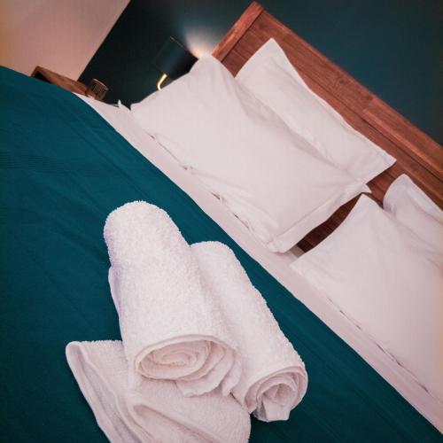 拉波瑟松的住宿－Bleu Nuit，一张带白色毛巾和枕头的床
