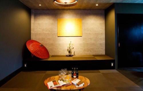 um quarto com uma mesa com copos de vinho e um candeeiro em Kyoto Nina em Quioto