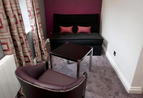 a bedroom with a bed and a table and chairs at St James Hotel; BW Premier Collection in Nottingham