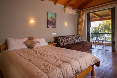 a bedroom with a large bed and a balcony at Pension Alexandros in Preveza
