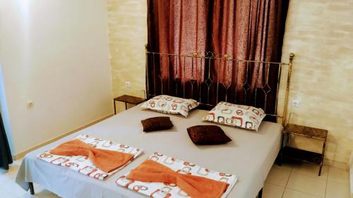a bed with three pillows on top of it at Dracena Guesthouse in Ravda