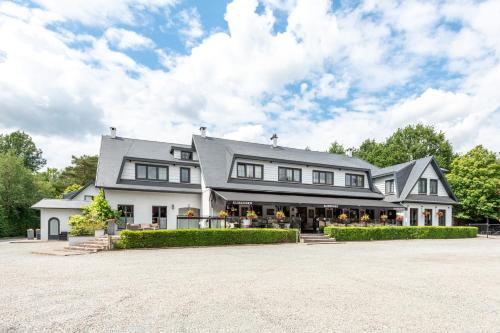 een groot wit huis met veel ramen bij Charmehotel Klokkenhof in Brasschaat