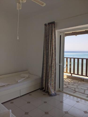 a bedroom with a bed and a view of the ocean at Seafront Apartment Pefkochori in Pefkochori