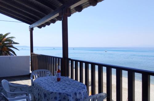 a table and chairs on a balcony with the beach at Seafront Apartment Pefkochori in Pefkohori