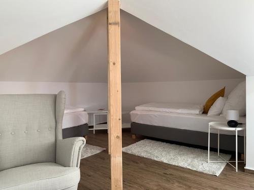 um quarto com uma cama, uma cadeira e um sofá em Ferienwohnung „Otto Lilienthal“ em Anklam