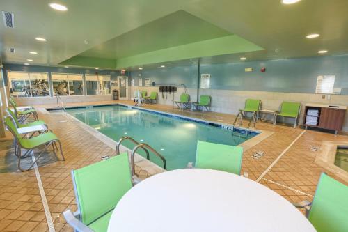 a swimming pool with chairs and a table and a table and a tablektop at Holiday Inn Express Hotel & Suites Richwood - Cincinnati South by IHG in Richwood