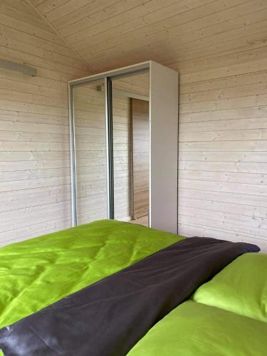 a bedroom with a green bed with a window at Rainbow Resort in Jastrzębia Góra
